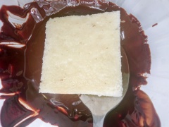 Chocolate bạn đặt vào lò vi sóng làm nóng cho chocolate tan chảy hoàn toàn, ngoài ra bạn cũng có thể hâm nóng cách thủy nhé. Nhúng bánh vào chocolate sao cho chocolate phủ kín mặt bánh, đặt bánh vào ngăn đông của tủ lạnh 1 - 2 phút cho phần chocolate đông lại.