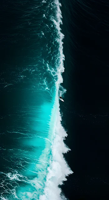 Aerial View of Surfer Riding Massive Teal Ocean Wave