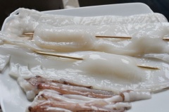 Mực làm sạch, rửa sơ với muối, để ráo. Khứa thân mực hình quả trám để gia vị dễ thấm vào mực. Dùng que tre xiên thân mực theo chiều dọc để khi nướng mực không bị cong lại.