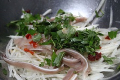 Vớt đu đủ ra cho vào thau khác, thêm tai heo, rau răm cắt nhỏ, 3 muỗng canh nước mắm, 2 muỗng canh đường, 2 muỗng cà phê nước cốt chanh và 2 muỗng canh nước lọc, trộn đều lên.