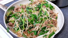 Phi thơm 1/2 tỏi băm với 1 muỗng cà phê dầu ăn, cho thịt bò vào đảo đều tay khoảng 1 phút. Sau đó, cho giá đỗ và hẹ đã cắt ngắn vào xào tiếp khoảng 2-3 phút cho giá đỗ dịu xuống là được.
