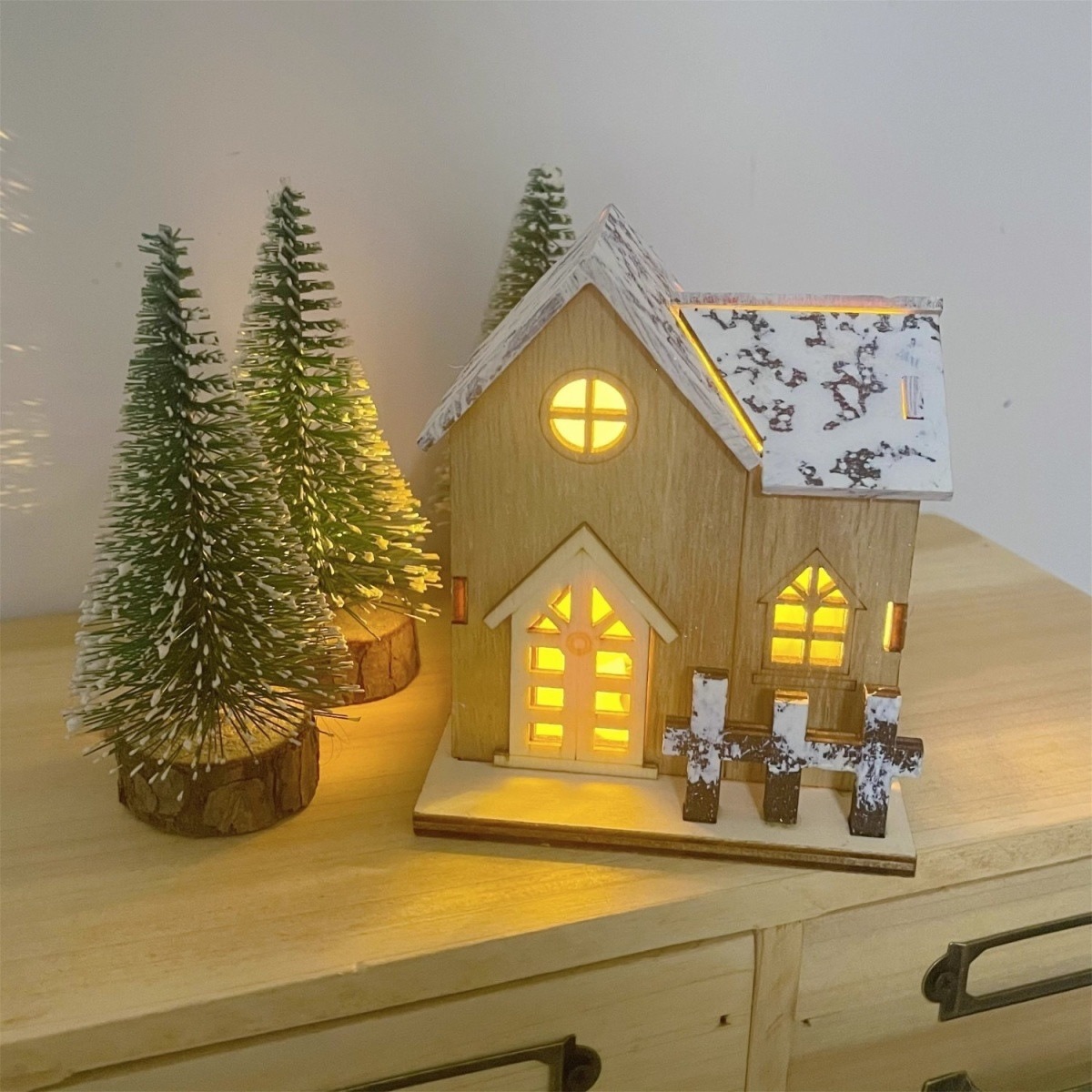 Illuminated Wooden Christmas House with Snowy Landscape