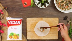 Chuẩn bị sẵn 1 gói bánh tráng bía (bánh tráng bò bía) cuốn chả giò. Trải bánh tráng ra mặt phẳng sạch, múc 1 lượng nhân vừa phải vào giữa (khoảng 1 muỗng canh nhân), thêm 1/6 quả trứng bắc thảo, sau đó gói lại và cuộn tròn chả giò. 1 mẹo nhỏ để chả giò nhìn đẹp mắt và lớp vỏ giòn hơn là sau khi gói nhân thì cuốn thêm bên ngoài 1 lớp bánh bía nữa.