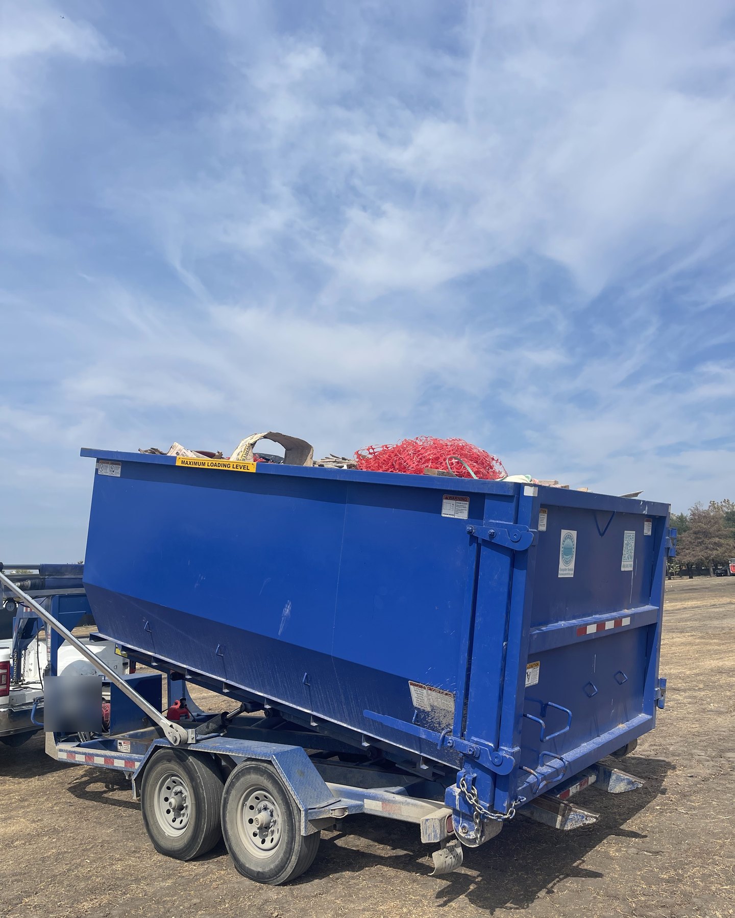 Full roll-off dumpster loaded on a trailer for haul-away in Wylie, TX