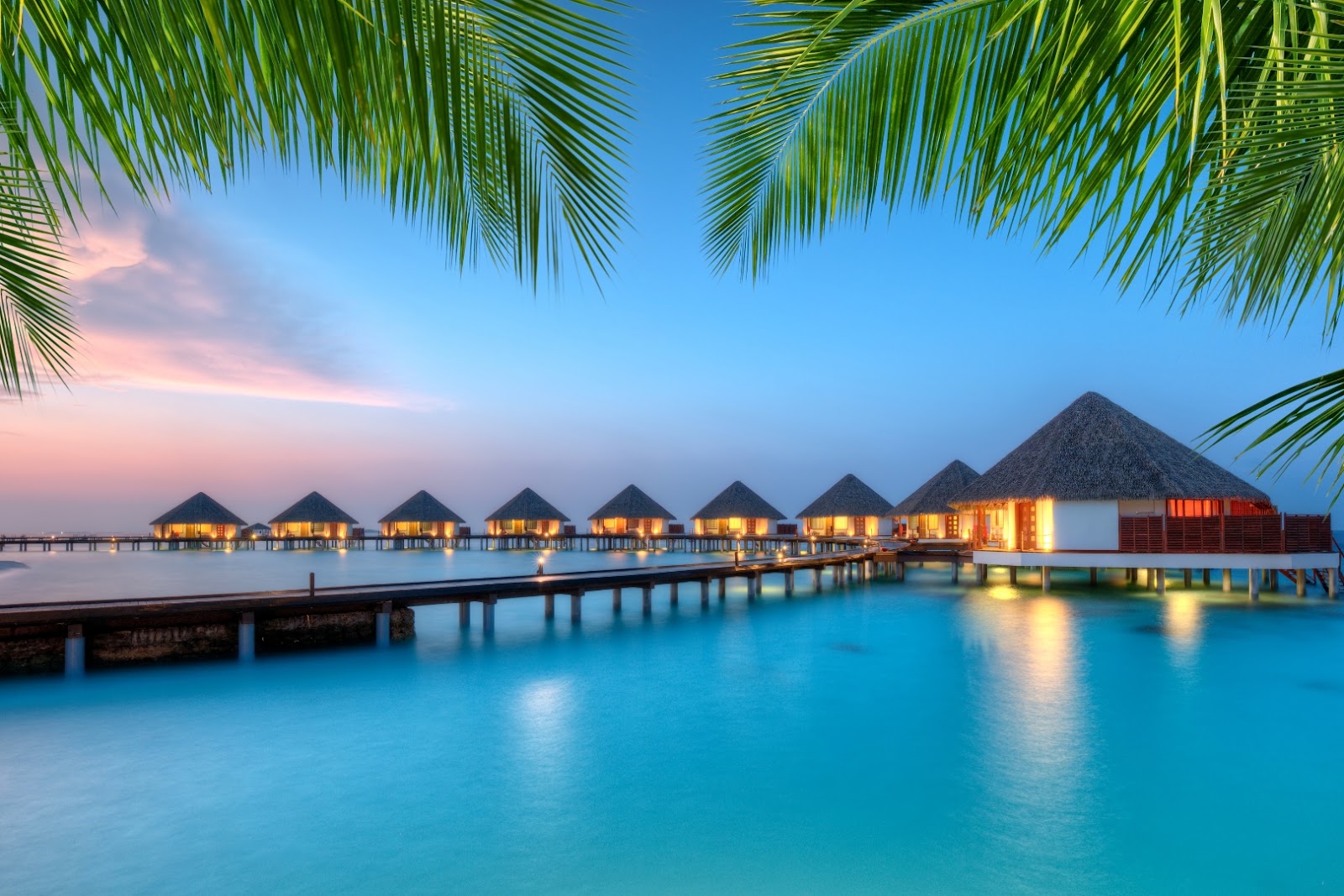 Luxury overwater villas stretching across a clear blue lagoon in the Maldives.