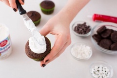 Bánh chín lấy ra, phủ lên mỗi chiếc cupcake bằng lớp kem whipping.