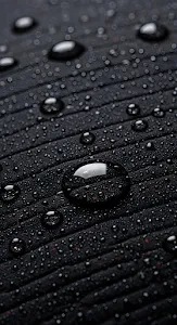 Black Fabric Texture with Reflective Water Droplets Macro