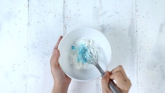 Phần trang trí màu xanh: Cho vào tô nhỏ 20gr kem dừa, 10ml siro dừa, 10ml sữa tươi và 1 giọt màu thực phẩm xanh dương. Dùng phới lồng khuấy đến khi màu hòa quyện vào hỗn hợp. Múc từng muỗng đổ vào đáy ly và xung quanh thành ly, để ly vào ngăn đông ít nhất 30 phút để phần hỗn hợp màu xanh đông cứng lại.