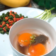 Nấm kim châm cắt nhuyễn. Đập 2 quả trứng vào chén, cho 2 muỗng canh nước mắm, 1 muỗng cafe tiêu xay, 1 muỗng cafe hạt tiêu, dùng đũa khuấy đều. Cho 1 muỗng canh dầu ăn vào chảo, cho phần đầu hành đã cắt khúc vào phi thơm.