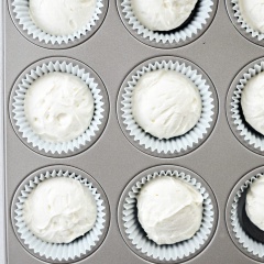 Kem phô mai đánh bông lên là được. Lót 12 chiếc bánh vào khuôn cupcake. Dùng muỗng múc kem múc từng viên kem phô mai lên trên bánh Oreo sao cho kem vượt mức khuôn một chút.