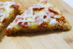 Cho bánh pizza mì tôm lên thớt và cắt miếng hình tam giác để thưởng thức. Pizza mì tôm mới lạ nhưng rất ngon miệng. Lớp mì giòn rụm, vừa thơm lại béo ngậy vị phô mai, đây là món ăn cuối tuần thú vị dành cho cả gia đình.