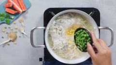Cho 1 lít nước vào nồi, nước bắt đầu sôi thì cho thêm gà xé dợi và nấm xé sợi vào nồi. Đảo đều. Sau đó cho thêm bắp mỹ và đậu Hà Lan vào nấu chung.