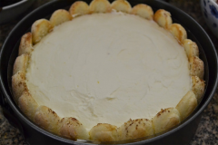 Chia phân nữa hỗn hợp phô mai Mascarpone vào khuôn và dàn đều lên khắp mặt bánh sampanh. Rây ít bột ca cao phủ đầy mặt phô mai. Sau đó các bạn lại nhúng bánh và xếp tiếp thêm 1 lớp lên mặt phô mai như vừa thực hiện.