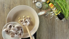 Làm nóng 3 muỗng canh dầu ăn trong chảo, cho tỏi cắt lát vào phi vàng thơm. Sau đó thêm bạch tuộc đã trụng vào xào sơ và nhanh tay ở lửa lớn. Nêm 2 muỗng cà phê hạt nêm vào bạch tuộc rồi đảo đều cho thấm gia vị.
