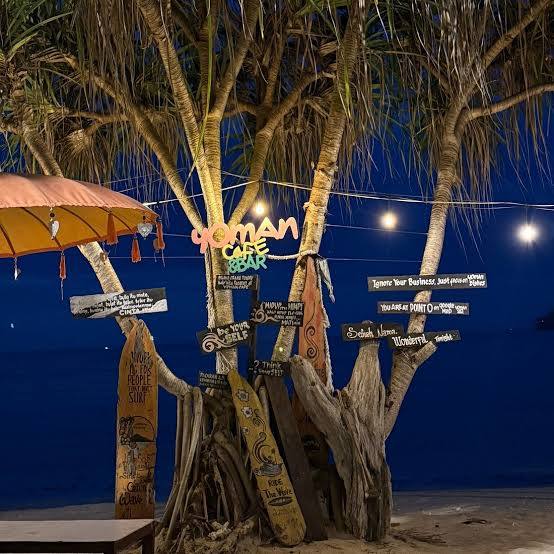 Hand-painted sign outside the Yoman beach cafe at dusk
