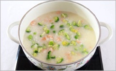 Cháo nhừ thì cho tiếp bông cải xanh vào, đun sôi.