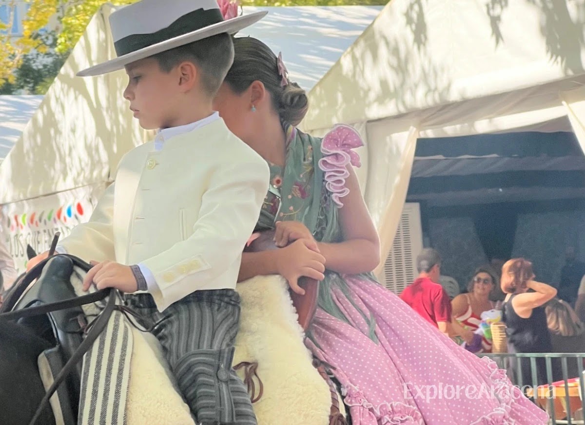 Two children riding together on a horse during the Feria de Aracena.