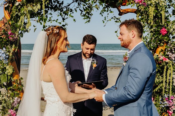 Vows at the floral arch on the beach