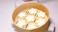 Phết chút dầu bắp lên miếng giấy dầu để chống dính. Đặt các miếng bột bánh bao sữa lên trên giấy. Xếp chúng vào chõ hấp bánh bao khoảng 15 phút. Mở nấp, để yên 2 phút rồi lấy bánh ra là có thể dùng nhé!