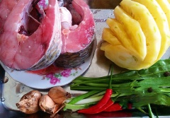 Cá mua về rửa sạch, cắt khúc rồi để ráo nước, sau đó tẩm ướp cùng với 1/3 muỗng cà phê tiêu, 1 muỗng cà phê bột canh để khoảng 10 phút cho ngấm. Thơm cắt miếng vừa ăn. Hành tím đập giập, hành lá thái nhỏ, ớt thái lát.