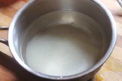Cho bột gelatine vào tô, thêm nước và khuấy đều 10 phút. Cho 470ml nước vào nồi cùng đường, bắc lên bếp nấu tan sau đó chế hỗn hợp gelatine vào vừa nấu vừa khuấy đều cho tan hết thì tắt bếp. Sau đó cho siro hoa hồng vào, khuấy đều lên.