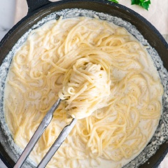 Bắc chảo lên bếp, cho bơ vào đun nóng, cho tỏi băm vào phi thơm, rót sữa và heavy cream vào đun với lửa cao cho đến khi sôi, sau đó vặn xuống lửa vừa, trộn đều phô mai với muối và tiêu rồi tiếp tục cho vào. Tắt lửa, trút mì Ý vào trộn cùng hỗn hợp. Rắc ngò tây băm là hoàn thành.