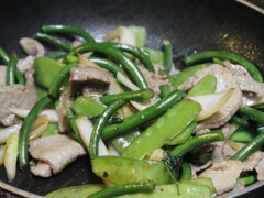 Đặt chảo lên bếp, cho dầu ăn vào đun nóng rồi cho tỏi vào phi thơm, cho thịt bò vào xào nhanh tay để thịt bò vừa chín tới, bạn đổ thịt ra dĩa và nhớ giữ lại nước thịt trong chảo nhé! Sau đó bạn cho thêm chút tỏi băm đảo đều rồi xào ngồng tỏi, đậu Hà lan và hành tây chung với nhau, nêm nếm lại cho hợp khẩu vị. Cuối cùng bạn cho thịt bò vào đảo nhanh cho nóng rồi tắt bếp.