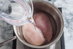Ức gà rửa sạch. Cho ức gà vào 1 cái nồi đủ rộng và trải trên 1 lớp duy nhất, không chồng chéo lên nhau, cho nước lạnh vào, sau đó lá nguyệt quế, muối, tiêu hạt, chanh lát vào, đậy nắp và luộc chín.