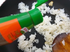 Khi cơm đã tơi hạt, thì thêm gia vị, ruốc sấy và hành lá cắt nhỏ rồi chiên thêm 5' nữa cho cơm đều hạt.