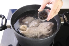 Trong 1 nồi khác, đun sôi 500ml nước. Cho bao tử heo, xương heo, hạt tiêu vào, nấu khoảng 30 phút.