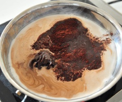 Vừa đun vừa hòa tan chocolate và ca cao. Đun cho sữa sôi thì tắt bếp, rót sữa ra ly và dùng nóng.