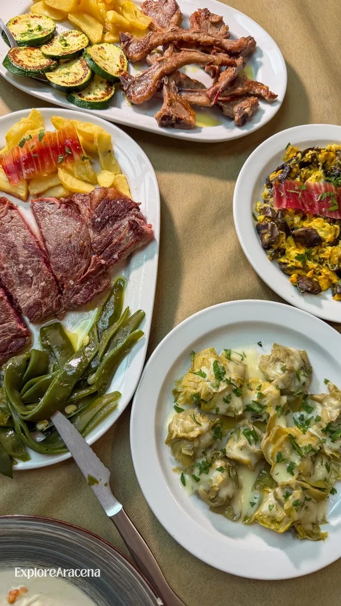 Shared plates including creamy artichokes, grilled meats, a vegetable-and-egg revuelto, fried potatoes and vegetables.