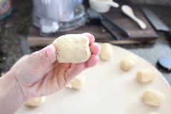 Cách làm bánh đậu gà nướng đơn giản: Lấy bột làm bánh đậu gà ra khỏi máy xay, dùng tay nhồi bột vài lần cho bột bánh dẻo mịn. Nặn bột bánh đậu gà thành từng viên tròn nhỏ đều nhau. Ấn dẹt 2 đầu bánh tạo thành khối hình trụ. Làm lần lượt cho đến khi hết bột. Xếp bánh đậu gà bánh lên giấy nến, cho vào lò nướng từ 10-12 phút.