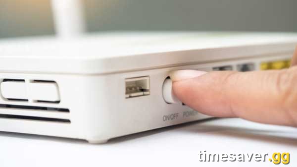 A finger pressing a home router's power button — a full modem/router power cycle is the single most reliable HUENEME-NEGEV fix