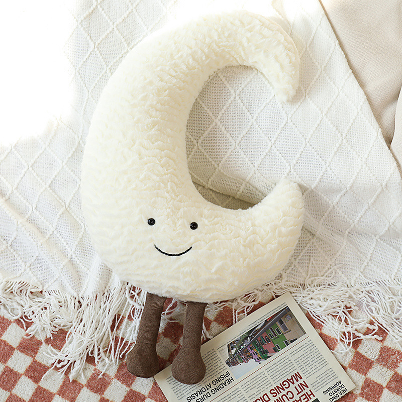 Decorative cuddle pillows with moon, star, and sun motif