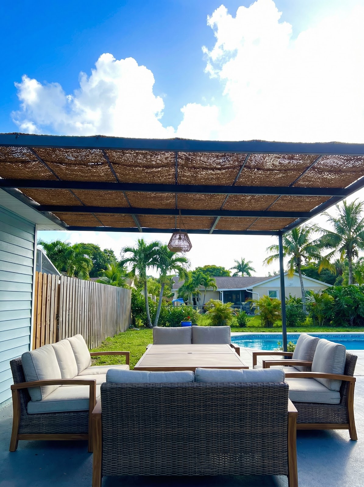 Pool patio lounge with metal frame and natural coir shade panels