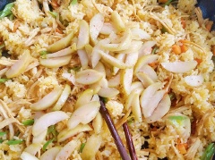 Cho tiếp hành tím vào phi thơm 1 muỗng canh dầu điều, cho cơm vào đảo đều, rồi cho 1 muỗng cà phê bột canh, 1/2 muỗng cà phê bột ngọt, 1/3 muỗng cà phê muối vào cơm. Khi hạt cơm săn lại, cho phần thịt gà đã xào vào cơm đảo đều. Khi cơm được, tắt bếp thì cho cóc chua ngọt vào đảo đều.