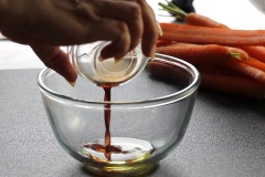 Mở lò nướng ở 190 độ C trước 10 phút. Trong âu trộn đều 1 muỗng dầu olive, 2 muỗng bơ và 2 muỗng giấm Balsamic. Cà rốt cắt bỏ phần lá xanh, giữ nguyên vỏ, rửa thật sạch, cắt làm đôi. Cho cà rốt vào khay nướng, xếp cho đều. Tỏi lột vỏ, bào mỏng.