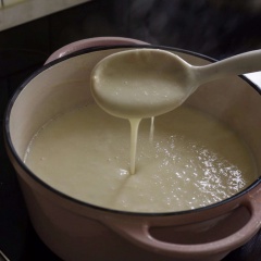 Đổ tiếp vào nồi soup gồm: 500ml sữa tươi không đường và 240ml kem sữa tươi, khuấy đều và đun sôi trong lửa nhỏ. Khi soup dày lên, thì thêm vào 2 muỗng canh phô mai parmesan bào nhỏ, muối cho vừa miệng.