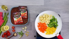 Bắc chảo nóng cho 1 muỗng canh dầu olive vào cùng cơm gạo lứt đã tẩm ướp xốt, chiên trong 5 phút rồi cho cơm ra tô riêng. Cũng chảo đó, bạn cho tiếp 40gr cà rốt, 40gr bắp non, 40gr bông cải xanh, 40gr bông cải trắng, 30gr bắp Mỹ và nêm 1 muỗng canh xốt gia vị hoàn chỉnh Barona - Thịt nướng sả, xào 2 phút.