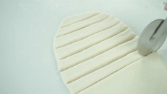 Cắt bột bánh quẩy thành những miếng dài khoảng 10-12cm, rộng 2cm. Nhúng tâm tre vào ly nước lạnh, ấn tâm tre vào giữa những miếng bột bánh quẩy rồi chồng 2 miếng bột lên nhau.