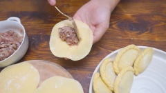 Cách xếp bánh gối nhân thịt đẹp mắt: Thêm nhân vào giữa vỏ bánh gối rồi gấp bánh lại làm đôi, miết chặt viền rồi gói viền theo hình xoắn để làm vỏ bánh đẹp hơn. Nếu chưa quen với cách làm bánh gối này thì bạn có thể dùng một chiếc nĩa để ép viền bánh lại nhìn cũng rất đẹp.