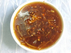 Cho gừng cắt sợi, 1/2 tỏi và hành tím còn lại, 2 muỗng cà phê mật ong, 1 muỗng cà phê dầu hào, 1 muỗng canh dầu mè, 1 muỗng canh nước tương, 1/2 muỗng cà phê tiêu, 1/2 muỗng cà phê ớt bột vào chảo, nấu nhỏ lửa đến khi sốt sệt lại, cho ra chén.