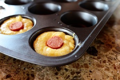 Chuẩn bị sẵn khuôn bánh muffins đã thoa một lớp chống dính, múc bột cho vào khuôn. Xúc xích cắt thành từng khúc nhỏ vừa đủ bánh và cho vào giữa bột. Đặt khay bột vào lò nướng từ 10 - 12 phút là bánh chín. Lấu bánh ra khỏi lò, chờ nguội một chút là có thể dùng được rồi nha.