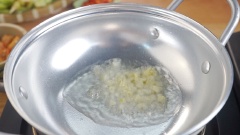 Làm nóng chảo với 2 muỗng canh dầu rồi phi 1 muỗng canh tỏi băm và 1 muỗng canh sả cho thật thơm. Cho tiếp 2 muỗng canh mắm tôm vào.