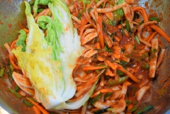 Đeo bao tay tránh bị cay bởi ớt bột. Quét phần hỗn hợp này vào từng lá cải thảo, phía trong và phía ngoài sau đó cuộn tròn cải thảo lại xếp vào trong hộp. Làm lần lượt cho đến hết, nén kim chi thật chặt từ trên xuống. Dùng giấy ăn lau sạch ớt bám xung quanh viền hộp. Đậy nắp kín, để ở nhiệt độ phòng khoảng 1-1.5 ngày.