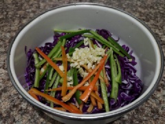 Cho bắp cải tím, ớt sừng và tỏi băm vào tô trộn, đổ hỗn hợp sốt trộn salad đã pha vào, trộn đều. Đun nóng 20ml dầu ăn rồi rưới vào tô salad, trộn đều lên.
