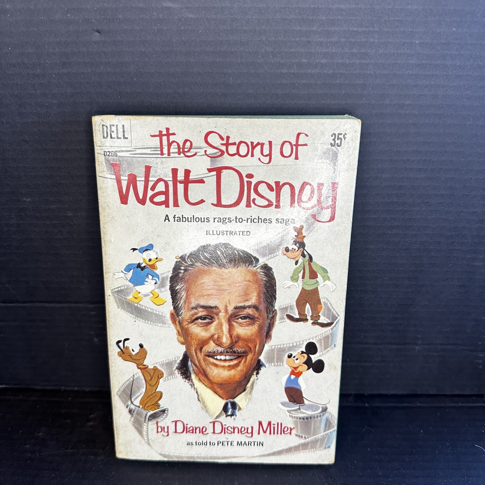Vintage mass-market paperback copy of The Story of Walt Disney by Diane Disney Miller, circa 1957–1959, showing spine wear and aged page tanning
