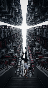 Low-Angle Urban Athletic Portrait of a Man Performing a Handstand in a Towering High-Rise Canyon