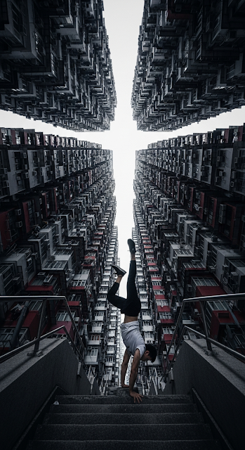 Low-Angle Urban Athletic Portrait of a Man Performing a Handstand in a Towering High-Rise Canyon - Free mobile Wallpaper
